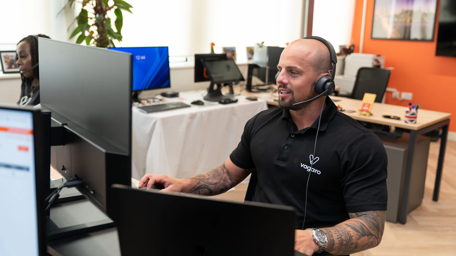 Office worker with a headset answering calls at a computer