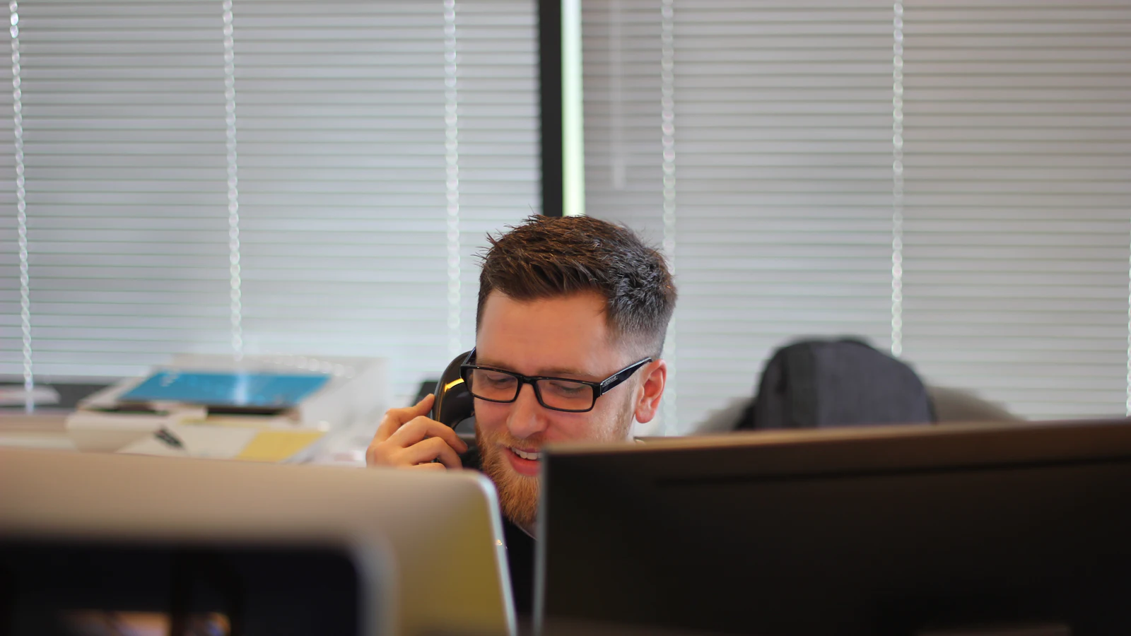 Office worker on a phone call at his desk
