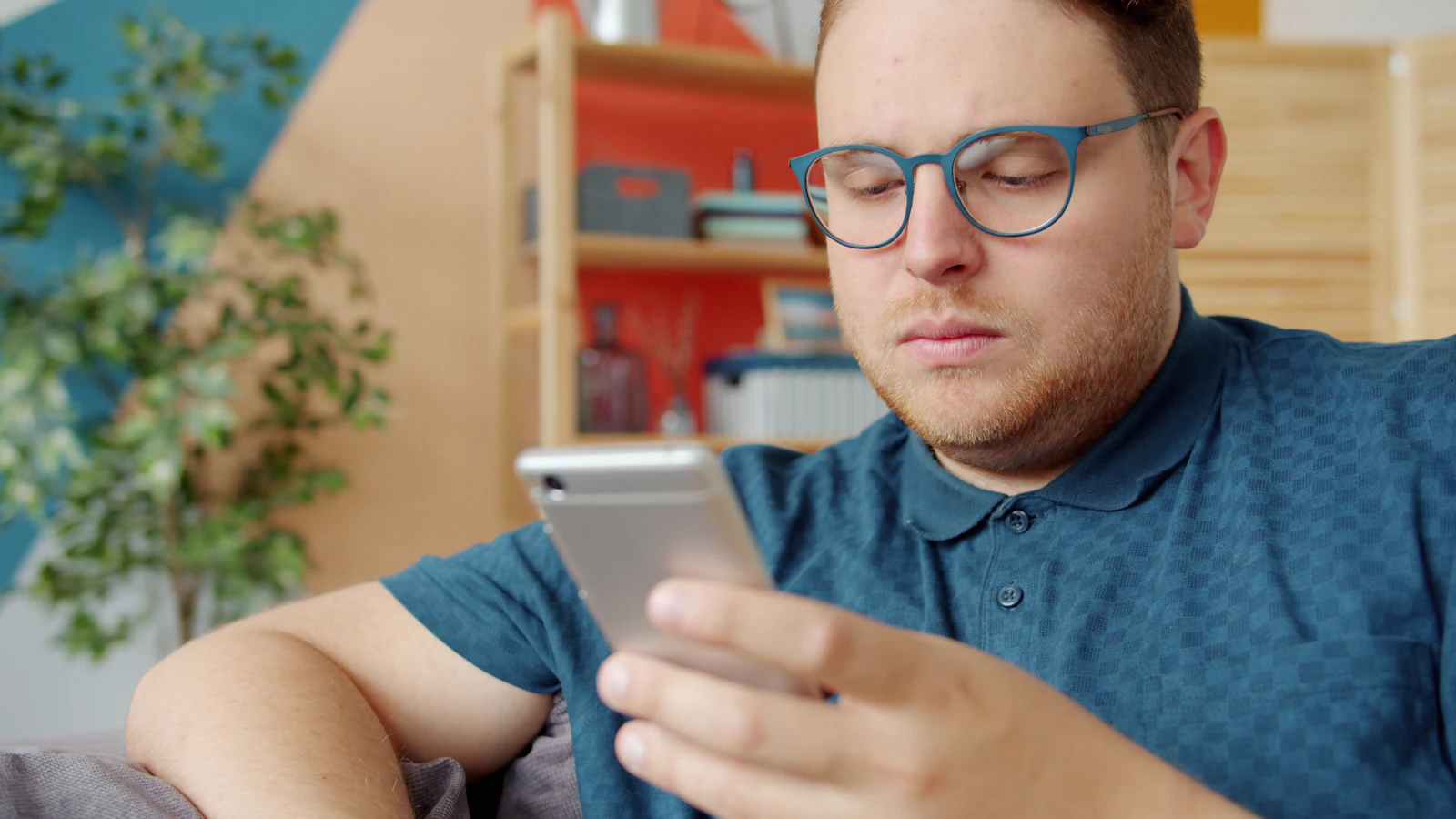 Man scrolling on a smartphone at home