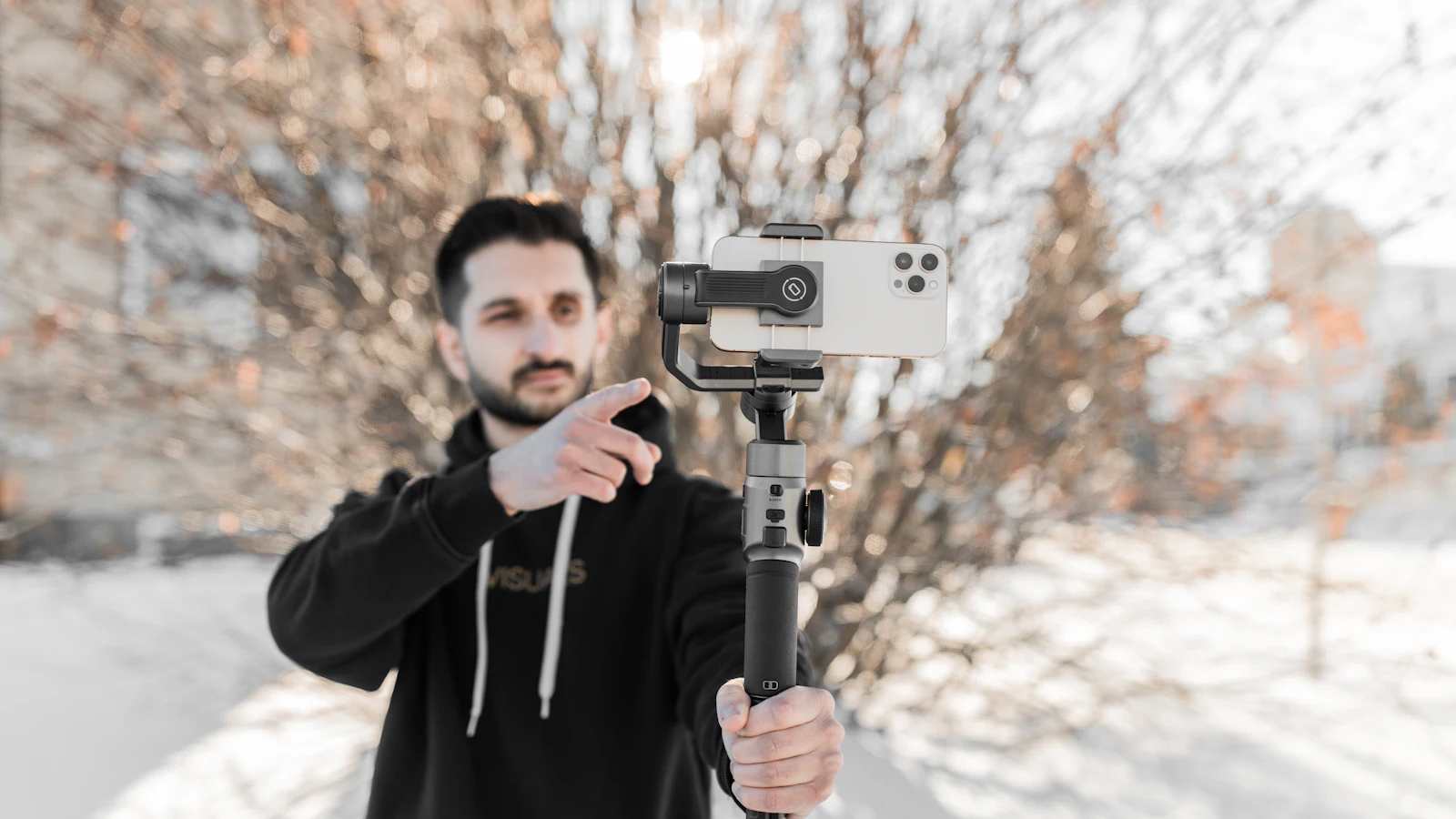 Man filming a video with a smartphone on a handheld gimbal