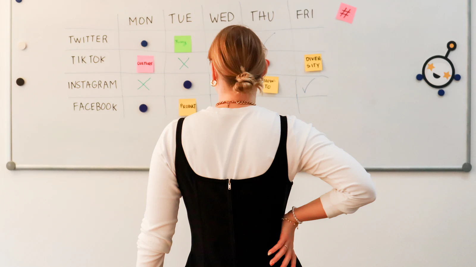 Woman planning a weekly schedule on an office whiteboard