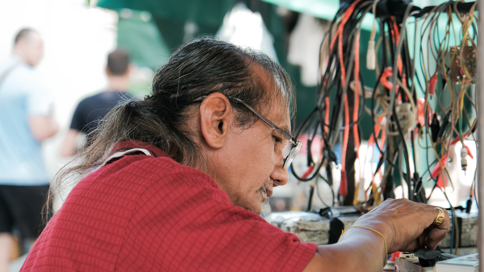 Technician working on wiring and equipment in a workshop
