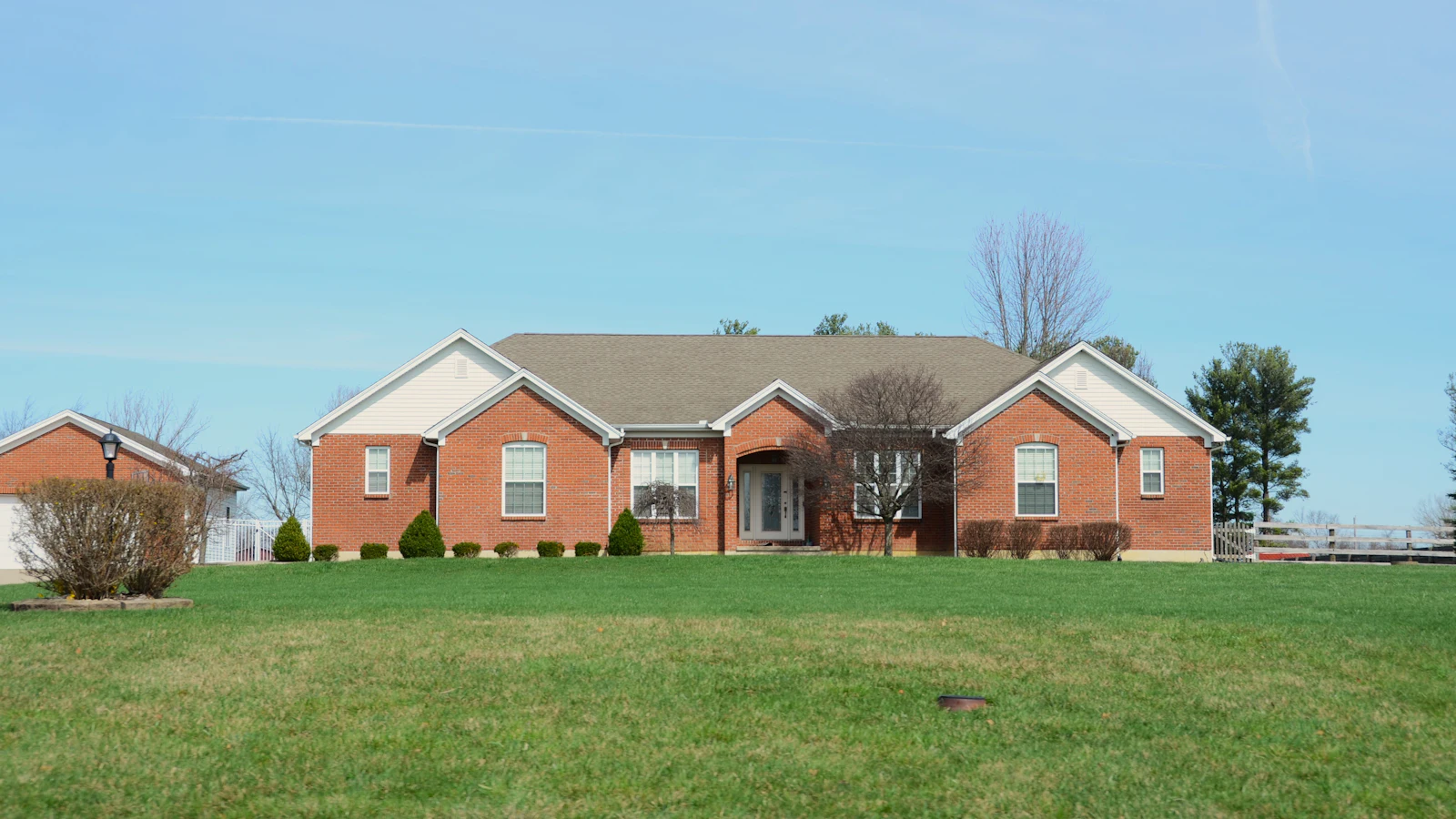 Single-story brick ranch home with a wide front lawn