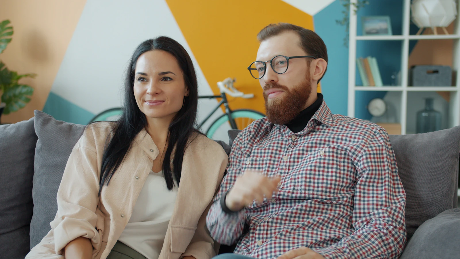 Couple sitting together on a sofa at home